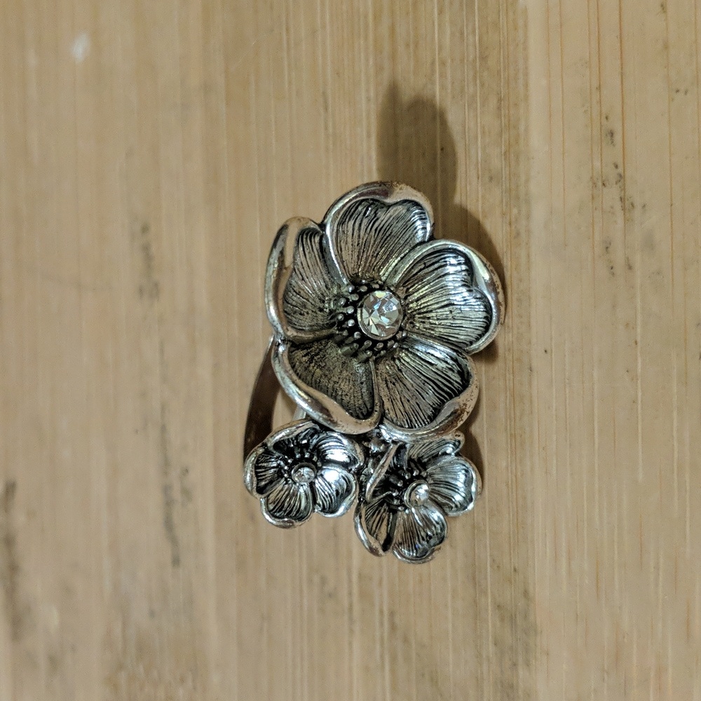 Silver toned ring. Beautiful three flowers with crystal s in the middlel.